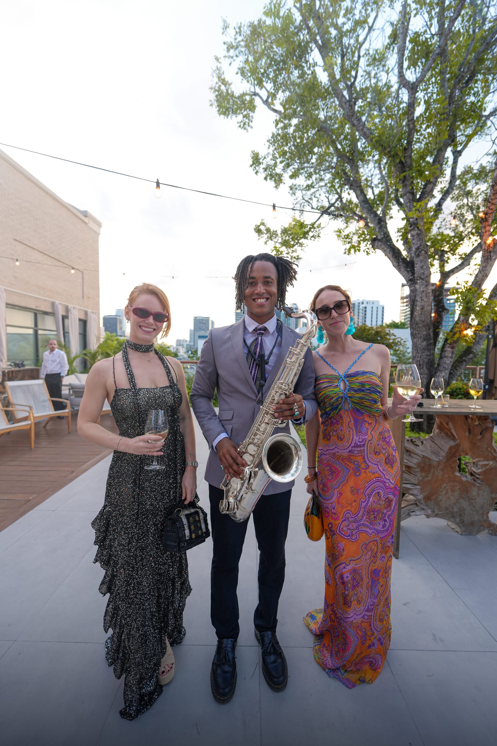 Rooftop party with a saxophonist performing among guests