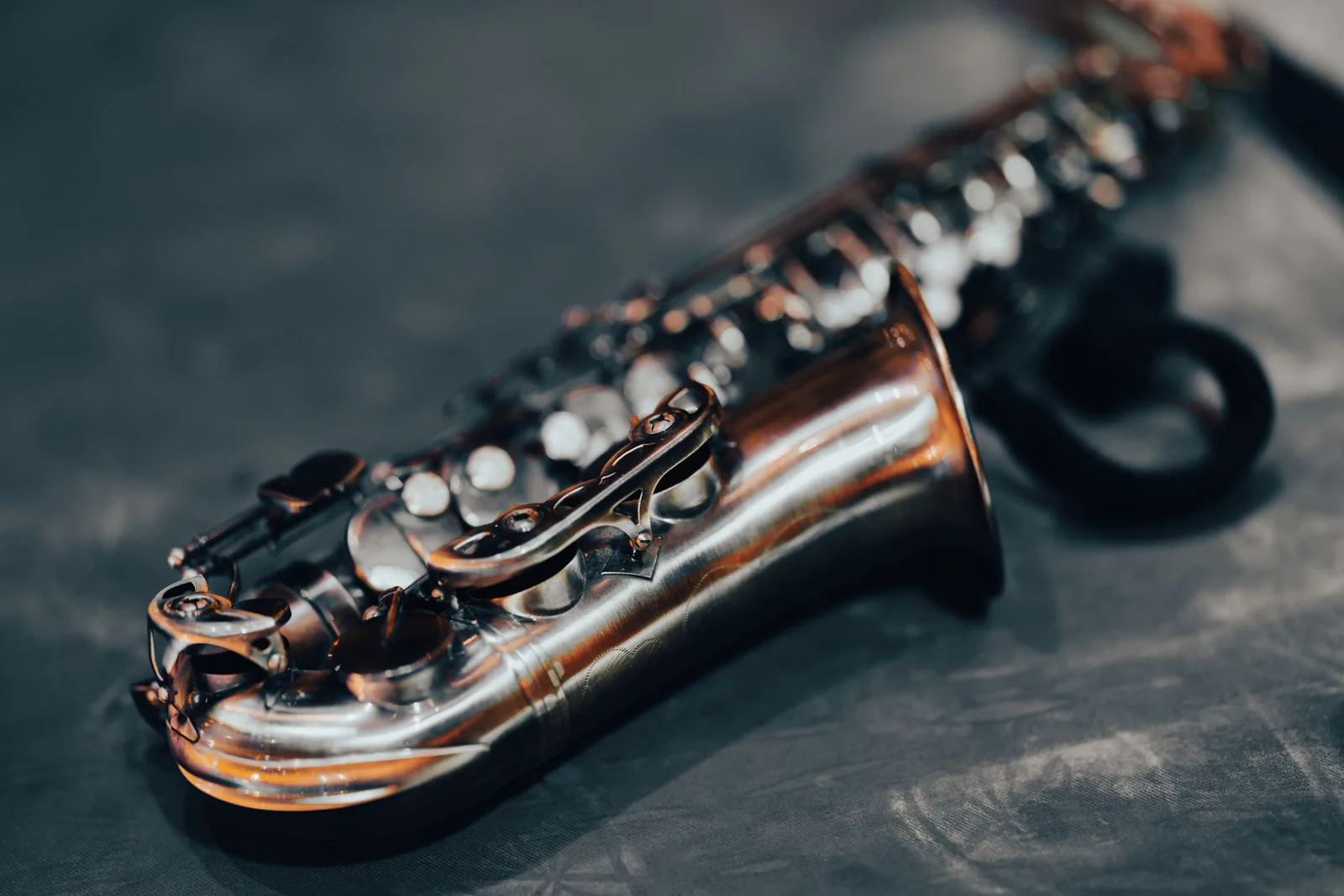 Brass saxophone catching warm light against darkness